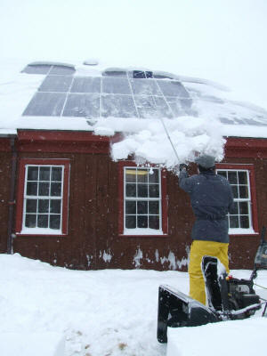 Clearing snow off the panels with a snor rake 2