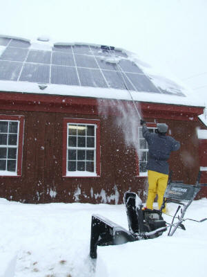 Clearing snow off the panels with a snow rake