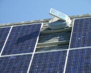 Solar attic vent shading a solar panel