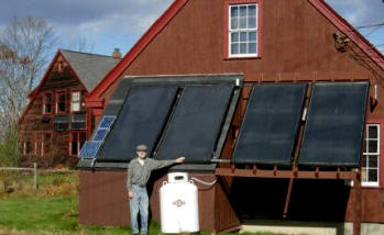 Guy posing with solar collectors on workshop